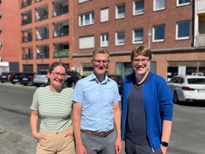 Marie Diekmann, Tilman Fuchs und Albert Wenzel vor einem Wohngebäude