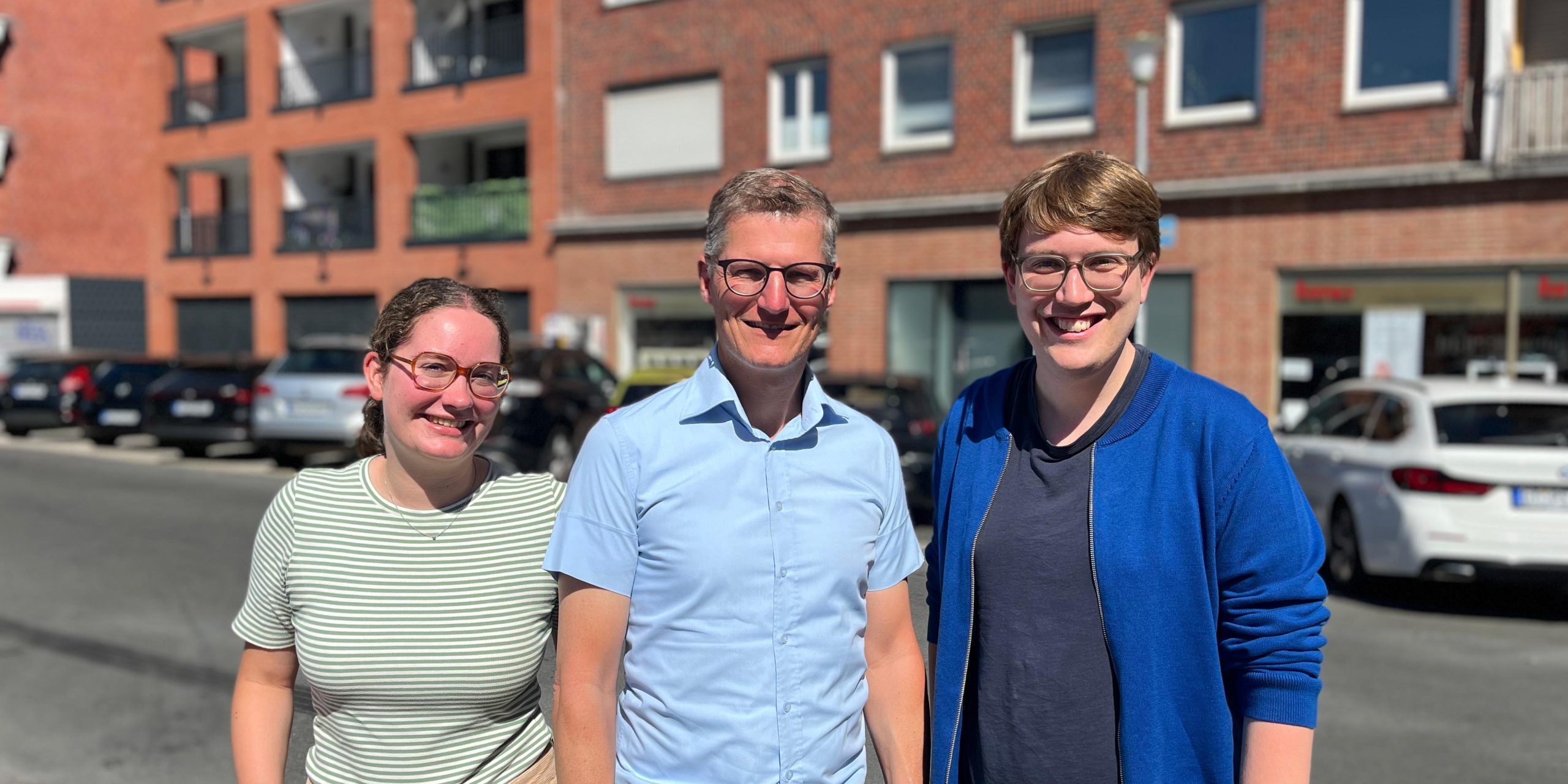 Marie Diekmann, Tilman Fuchs und Albert Wenzel vor einem Wohngebäude