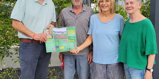 Bezirksbürgermeister Benedikt Spangenberg und die BV-Kandidat*innen Bodo Kensmann, Heike Deckert-Peaceman und Margret Wesseling mit einem Grünen Flyer